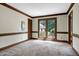 A large living room with carpet, dark wood trim, and large windows for natural light at 7204 Bellweather N Ct, Raleigh, NC 27615