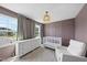 Cozy Bedroom with a crib, accent wall, and chair by the window at 77 Rolling Creek Cir, Clayton, NC 27520