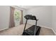 Bright workout room featuring a modern treadmill and a window view to the outside at 77 Rolling Creek Cir, Clayton, NC 27520
