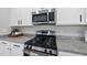 Close-up of stainless steel appliances and granite countertops in a modern kitchen at 77 Rolling Creek Cir, Clayton, NC 27520