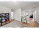 Spacious upstairs hallway with light-colored wood floors, playroom, and ample lighting at 77 Rolling Creek Cir, Clayton, NC 27520