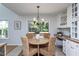 The eat-in kitchen features a wood table, wicker chairs, and a large window for natural light at 802 Wakehurst Dr, Cary, NC 27519
