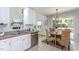 Bright eat-in kitchen features stainless steel appliances, white cabinets, and a view to the living room fireplace at 802 Wakehurst Dr, Cary, NC 27519