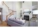 Open-concept living room featuring a cozy fireplace, built-ins, and staircase at 802 Wakehurst Dr, Cary, NC 27519