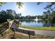 Scenic view of a pond with a fountain, trees, and a bench, perfect for enjoying nature and relaxation at 802 Wakehurst Dr, Cary, NC 27519