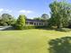 Charming home featuring a well-manicured lawn, mature trees, and a welcoming screened porch perfect for outdoor enjoyment at 9 Lakeview Dr, Sanford, NC 27332
