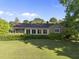 Charming brick home featuring large windows, manicured landscaping, a screened porch, and mature trees for a serene setting at 9 Lakeview Dr, Sanford, NC 27332