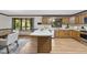 Bright kitchen featuring wood cabinets, laminate floors, an island, and a window above the sink at 9 Lakeview Dr, Sanford, NC 27332