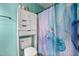 The bathroom is equipped with a toilet, cabinet, and shower curtain with blue and gold patterns at 901 Currin Perry Rd, Zebulon, NC 27597