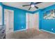 Bedroom with light carpet, vibrant blue walls, two closets, ceiling fan, and palm tree artwork at 901 Currin Perry Rd, Zebulon, NC 27597
