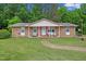 Charming brick home with a well-maintained front yard and inviting entrance with rocking chairs on the porch at 901 Currin Perry Rd, Zebulon, NC 27597