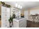 Kitchen area featuring a movable island, white cabinets, and hardwood floors, with view into dining area at 901 Currin Perry Rd, Zebulon, NC 27597