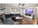 Cozy living room with a sectional sofa, hardwood floors, and a modern entertainment center with fireplace at 901 Currin Perry Rd, Zebulon, NC 27597