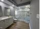 Modern bathroom featuring double vanity, white marble countertop, and frameless glass shower with a built-in bench at 9013 Tenderfoot Trl, Raleigh, NC 27615