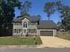 Charming two-story home featuring a well-manicured lawn, gray siding, and an attached garage at 9013 Tenderfoot Trl, Raleigh, NC 27615