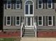 Close up of charming two-story home featuring front door with decorative glass and manicured landscaping at 9013 Tenderfoot Trl, Raleigh, NC 27615