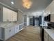 Kitchen with white cabinets, modern hardware, marble countertops, with black cabinetry in the connected dining area at 9013 Tenderfoot Trl, Raleigh, NC 27615