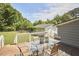 Inviting back deck featuring a glass top table and a scenic backyard with a lush lawn and mature trees at 909 Goodwin Rd, Durham, NC 27712