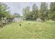 Expansive backyard featuring lush green grass, scattered trees, a swing set and fencing at 909 Goodwin Rd, Durham, NC 27712