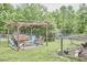 Relaxing backyard features a charming pergola with swing and an enclosed chicken coop at 909 Goodwin Rd, Durham, NC 27712