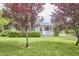 Quaint one-story home featuring a lush front yard and mature trees at 909 Goodwin Rd, Durham, NC 27712