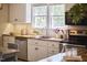 Bright kitchen features white cabinets, stainless steel appliances, and a view to the backyard at 909 Goodwin Rd, Durham, NC 27712