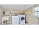 Laundry room featuring white washer and dryer, utility sink, and a window at 909 Goodwin Rd, Durham, NC 27712