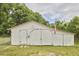 Large outbuilding with wooden doors and American flag offers ample space for storage at 909 Goodwin Rd, Durham, NC 27712