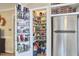 Walk-in pantry with organized shelving, a side-mounted beverage rack, and a stainless steel refrigerator at 909 Goodwin Rd, Durham, NC 27712
