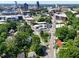 Aerial view of a home in a neighborhood with the city skyline in the background, lush trees, and a street at 913 Washington St, Durham, NC 27701