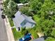An aerial view of the home shows the roof, street, a blue car, and surrounding lush, green trees at 913 Washington St, Durham, NC 27701
