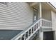 Image of the house's back entrance showcasing the stairs, landing, and neutral colors of the siding at 913 Washington St, Durham, NC 27701