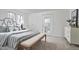 A bright bedroom showcases a queen bed, modern dresser, and door leading to outdoor space at 913 Washington St, Durham, NC 27701