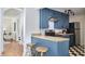 A renovated kitchen features blue cabinetry, stainless steel appliances, and bar stool seating at the counter at 913 Washington St, Durham, NC 27701