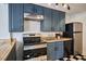 A modern kitchen showcases blue cabinets, stainless steel appliances, and black and white checkerboard flooring at 913 Washington St, Durham, NC 27701