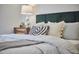 Close up of main bedroom showcasing the bed with pillows, side table, and a stylish lamp with great detail at 913 Washington St, Durham, NC 27701