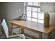 Inviting office area with light wood desk illuminated by natural light; complete with modern chair and stylish lamp at 913 Washington St, Durham, NC 27701
