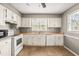 Bright kitchen featuring white cabinetry, neutral countertops, and efficient appliances for easy meal preparation at 919 Lexington Ct, Cary, NC 27511