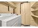 Functional laundry room with washer, dryer, storage shelves and a neutral color palette at 919 Lexington Ct, Cary, NC 27511