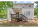 Back exterior showcasing a two-story home with a wooden deck and concrete patio at 100 Full Moon Ct, Garner, NC 27529