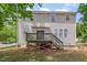The back exterior shows a charming home with a wooden deck and a concrete patio in a green backyard at 100 Full Moon Ct, Garner, NC 27529