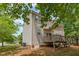 Back exterior view shows home with a deck and patio in a yard shaded by mature trees at 100 Full Moon Ct, Garner, NC 27529