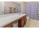 Bathroom featuring a vanity and sink, with a shower-tub combo, and a framed mirror at 100 Full Moon Ct, Garner, NC 27529