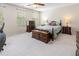 Bright bedroom with carpet floors, two windows, and classic wood furniture at 100 Full Moon Ct, Garner, NC 27529