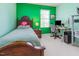 Bright and vibrant bedroom with green walls, a comfortable bed, and a practical study area at 100 Full Moon Ct, Garner, NC 27529