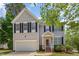 Charming two-story home with black shutters, a well-kept lawn and garage, surrounded by mature trees at 100 Full Moon Ct, Garner, NC 27529