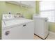 Bright laundry room with white washer and dryer units and convenient overhead storage at 100 Full Moon Ct, Garner, NC 27529