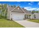 Charming home featuring stone accents, a two-car garage, and a well-manicured lawn at 1009 Rhino Bnd, Oxford, NC 27565