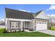 Charming home with stone accents, gray siding, manicured lawn, and a convenient attached two-car garage at 1009 Rhino Bnd, Oxford, NC 27565