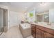 Bright bathroom with double sinks, soaking tub, glass shower, and tile floors at 1009 Travern Dr, Raleigh, NC 27603